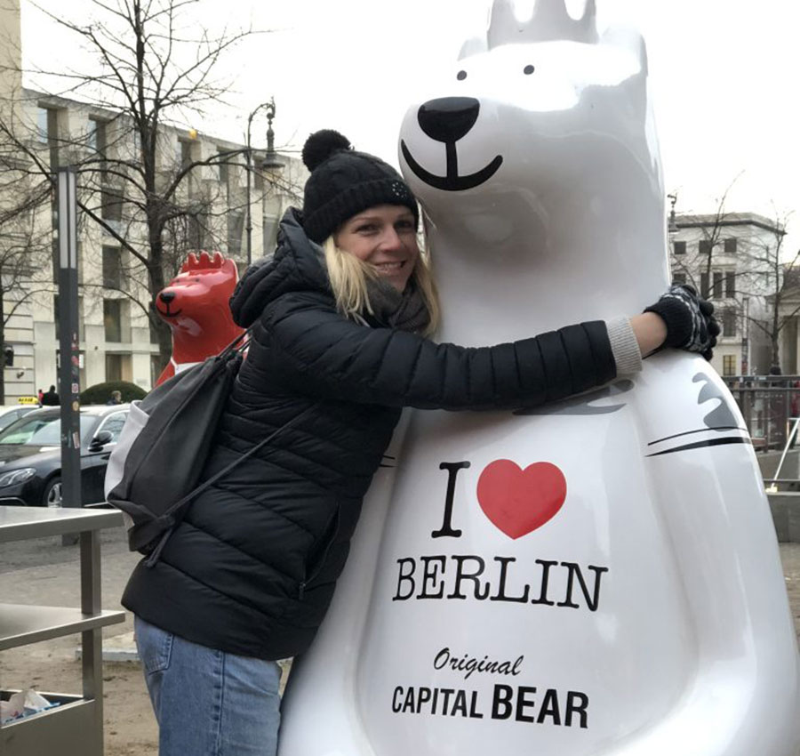 Jo Harten hugging a statue of a bear in Berlin